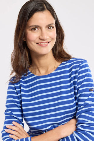 Woman wearing blue and white striped Armor-Lux long sleeve shirt, arms crossed, smiling