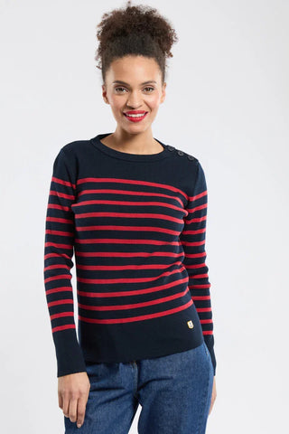 Woman wearing a navy blue and red striped sweater with button details, paired with blue jeans