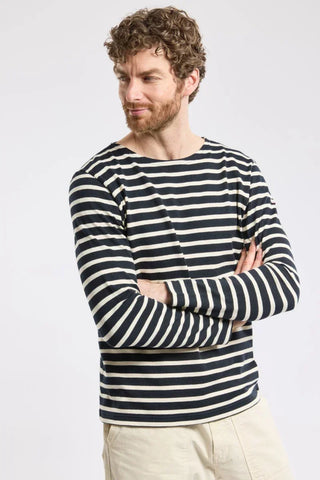 Man wearing navy and white striped long sleeve shirt with light beige pants