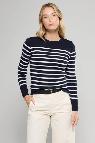 Woman wearing navy blue striped sweater and beige pants with black belt