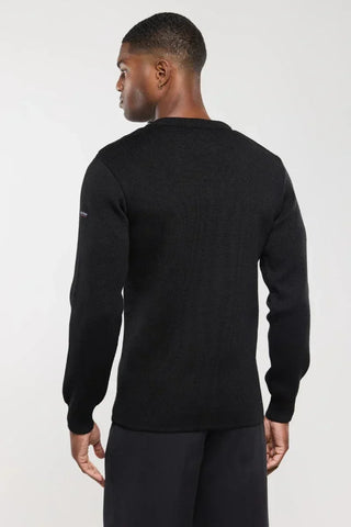 Man wearing black knit long-sleeve sweater, viewed from the back, on white background