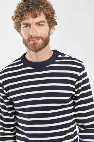 Man wearing navy and white striped Breton sweater with shoulder buttons