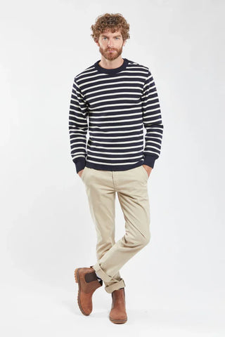 Man wearing navy striped sweater, beige pants, and brown boots on white background