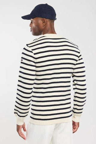 Man wearing navy and white striped sweater and navy cap, viewed from the back