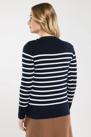Woman wearing navy and white striped long sleeve sweater, back view