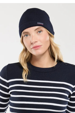 Woman wearing navy knit beanie and navy striped sweater, casual winter fashion
