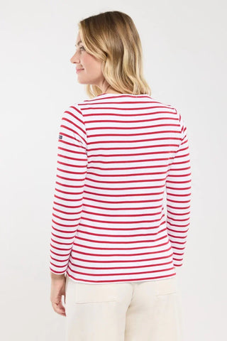 Woman wearing a white and red striped long sleeve shirt with cream pants, back view