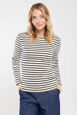 Woman wearing a navy and white striped long-sleeve top and blue pants, front view