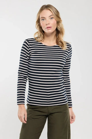 Woman wearing navy and white striped long sleeve shirt with olive green pants