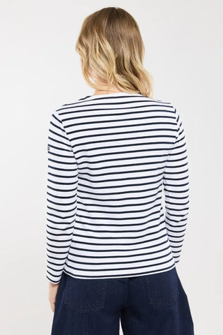 Woman wearing long sleeve white and navy striped shirt, back view