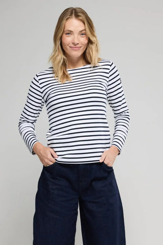 Woman wearing a white and navy striped long-sleeve shirt with dark wide-leg pants