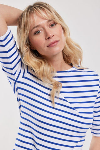 Woman wearing blue and white striped Breton shirt with 3/4 sleeves