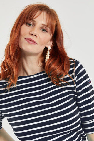 Woman wearing navy and white striped Breton shirt with 3/4 sleeves, casual style