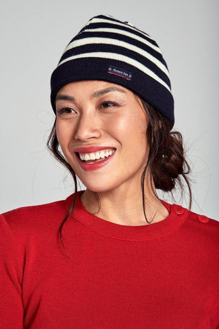 Smiling woman wearing a navy and white striped wool beanie and red sweater