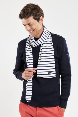 Man wearing a navy sweater and white cotton scarf with navy stripes, casual style