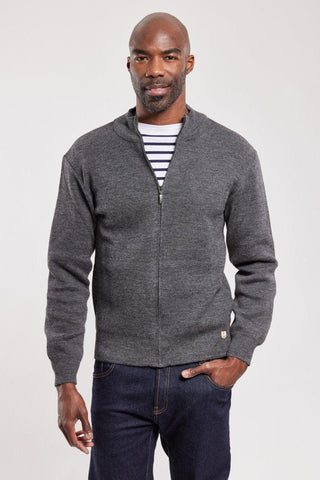 Man wearing a grey wool zip-up cardigan over a striped shirt and dark jeans