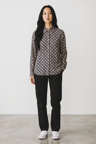 Modèle portant une blouse Le Capitaine D'a Bord à carreaux géométriques bleus et beiges en viscose à manches longues.