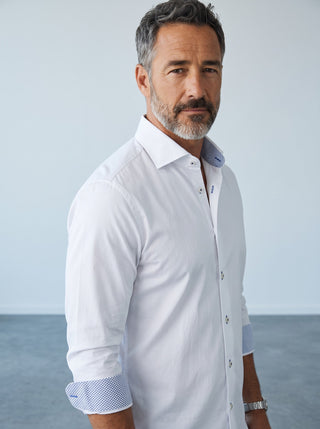 Homme portant une chemise blanche Emanuel Berg Byron en maille extensible avec détails à motifs aux poignets et col.