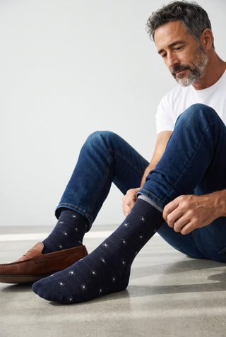 Homme portant des bas marine à motif fleurs Bugatchi en coton et cachemire, avec un jean et des mocassins en cuir.