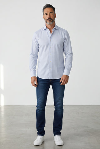 Homme portant une chemise Emanuel Berg Rialto bleue à motifs, coupe moderne, avec un jean bleu et des baskets blanches
