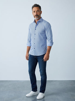 Homme portant une chemise à rayures bleues Emanuel Berg Byron en maille extensible avec un jean et des baskets