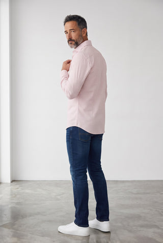 Homme portant une chemise Emanuel Berg Byron rose vif à carreaux en maille extensible, avec un jean bleu et des baskets