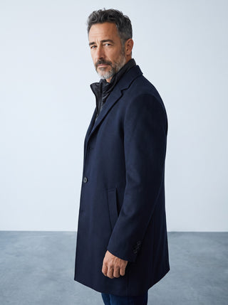 Homme portant un manteau en laine bleu marine Digel Deus avec col zippé amovible, coupe moderne, vue de profil.