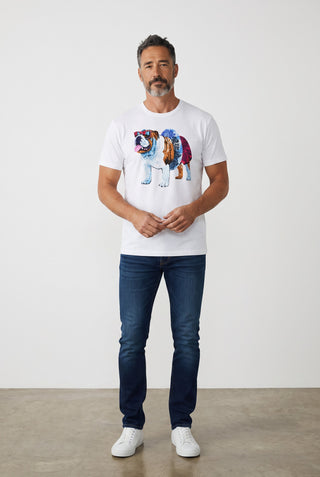 Homme portant un t-shirt blanc 100% coton Le Capitaine D'a Bord avec un imprimé coloré de chien à la piscine