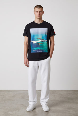 T-shirt noir en coton Le Capitaine D'a Bord avec imprimé Maldives Raid et détails en soie, porté par un mannequin.