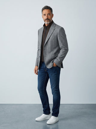 Homme portant un veston gris en laine Digel avec col zippé détachable marron, jean bleu et baskets blanches