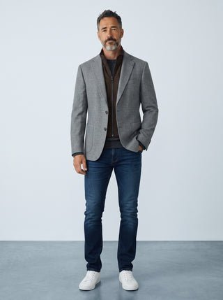 Homme portant un veston en laine gris Le Capitaine D'a Bord avec col zippé détachable, jean bleu et baskets blanches