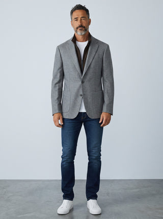 Homme portant un veston en laine gris Digel avec col zippé détachable marron, jean bleu et baskets blanches