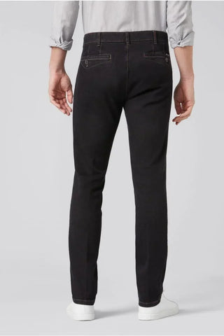 Back view of man wearing slim-fit black Meyer jeans with buttoned pockets