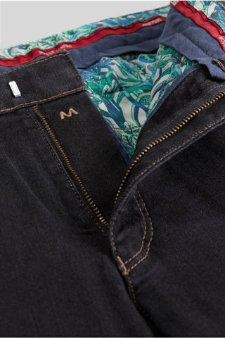 Close-up of dark denim jeans with colorful patterned inner lining and visible zipper