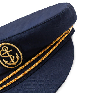 Navy blue captain’s hat with gold anchor emblem and braided trim on white background