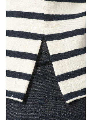 Close-up of navy and white striped cotton shirt hem over dark denim jeans