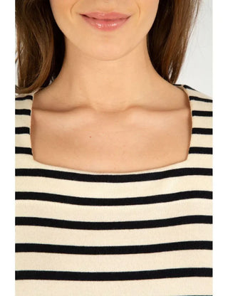 Woman wearing a short-sleeve black and white striped boatneck top