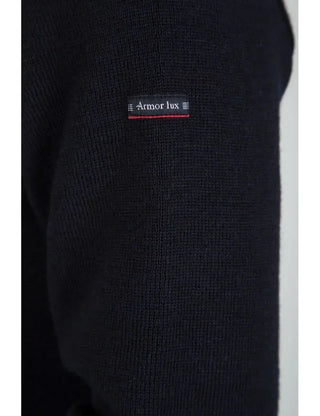 Close-up of navy wool knit sweater sleeve with small Armor Lux label