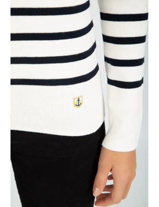 White cotton striped sweater with navy blue lines and anchor patch, worn with black pants