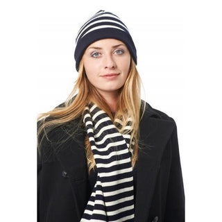 Woman wearing navy and white striped wool beanie and matching scarf over black coat