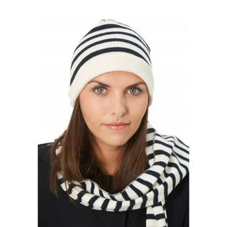 Woman wearing a black and white striped wool beanie and matching scarf