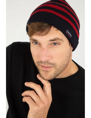 Man wearing a navy and red striped knit beanie and black sweater, close-up view