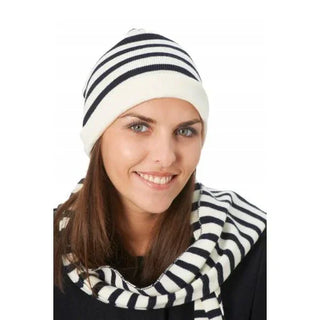 Woman wearing a navy and white striped knit beanie and matching striped scarf