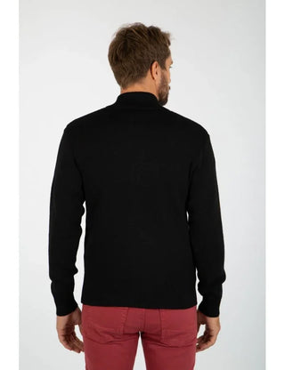 Man wearing a black wool zip cardigan and red pants, shown from the back.