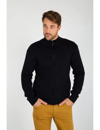 Man wearing a navy zip-up wool cardigan and mustard pants, front view, neutral background