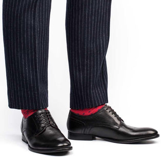 Men's black leather dress shoes with lace-up design, worn with pinstripe pants and red socks