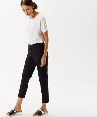Woman wearing black cotton satin capri pants and white t-shirt on white background
