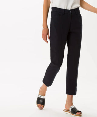 Woman wearing black cotton satin capri pants and black silver sandals on white background