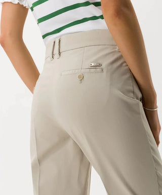 Back view of beige cotton satin capri pants with rear pockets, worn by woman