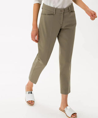 Woman wearing khaki cotton sateen capri pants and white sandals on white background